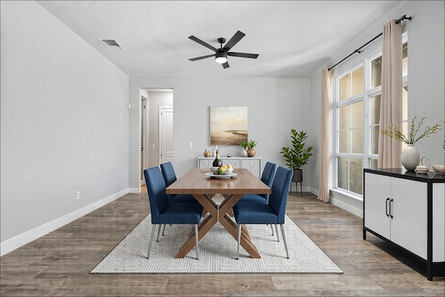 dining space featuring a ceiling fan, baseboards, visible vents, and wood finished floors