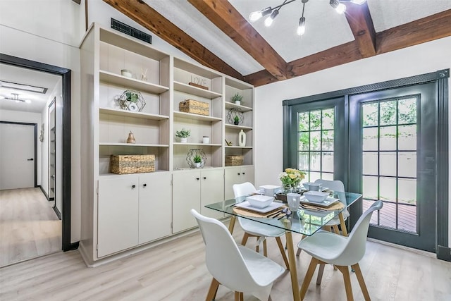 dining room with light wood-style floors, visible vents, and lofted ceiling with beams