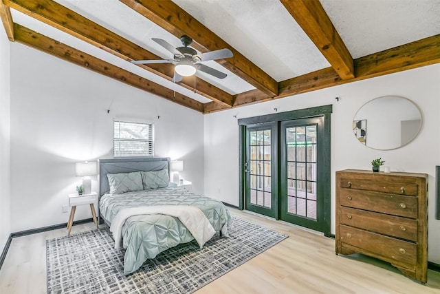 bedroom featuring lofted ceiling with beams, access to outside, wood finished floors, and baseboards