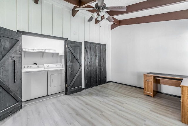 interior space featuring light wood finished floors, a barn door, ceiling fan, washer and dryer, and laundry area