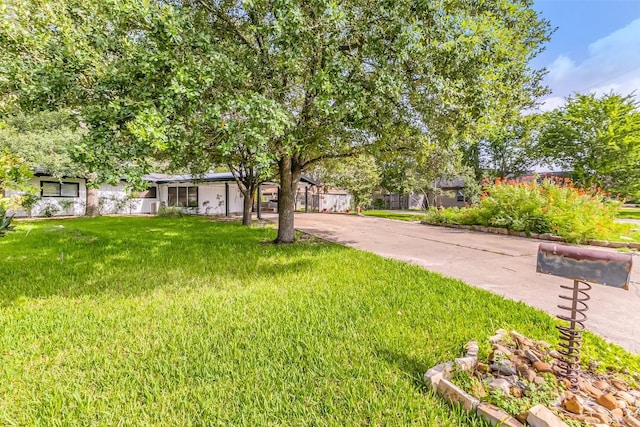 exterior space featuring concrete driveway and a front yard