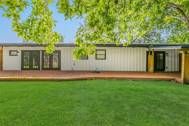 rear view of house featuring french doors, a lawn, and a wooden deck