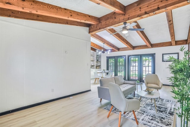 living area featuring vaulted ceiling with beams, ceiling fan with notable chandelier, baseboards, and light wood-style floors