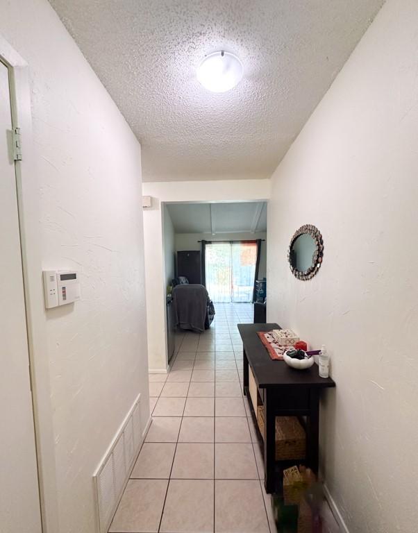 902 Austin Highlands Blvd, Austin, TX 78745 - corridor with a textured ceiling and light tile patterned floors