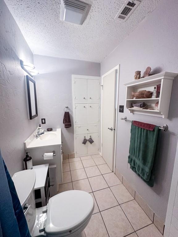 bathroom with tile patterned flooring, visible vents, a textured ceiling, and vanity