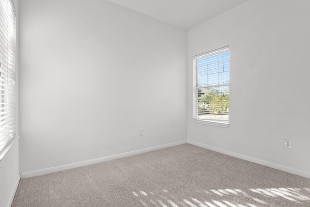 carpeted empty room featuring baseboards