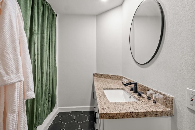 full bath with curtained shower, tile patterned flooring, vanity, and baseboards