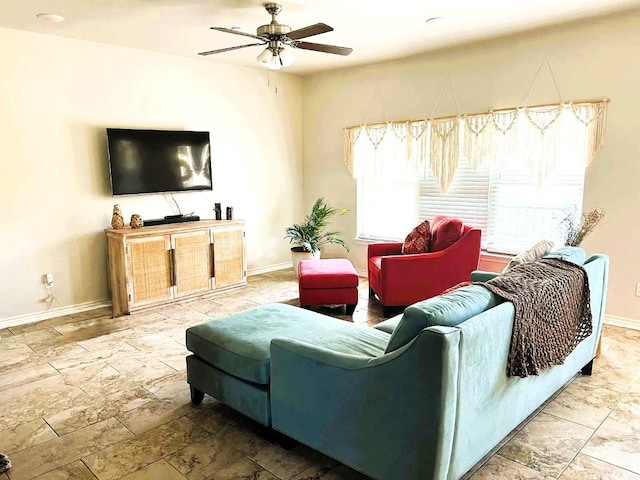 living area with ceiling fan and baseboards