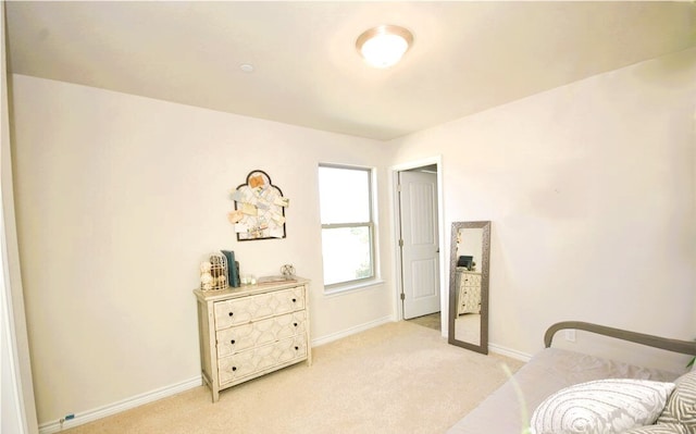 living area with baseboards and light colored carpet