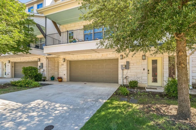 205 Birch Oak Ln, Georgetown, TX 78628 - townhome / multi-family property with concrete driveway, a garage, stone siding, and a balcony