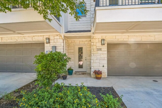 205 Birch Oak Ln, Georgetown, TX 78628 - entrance to property featuring a balcony, driveway, stone siding, and an attached garage