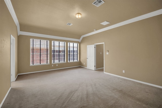 empty room with carpet flooring, visible vents, baseboards, and ornamental molding