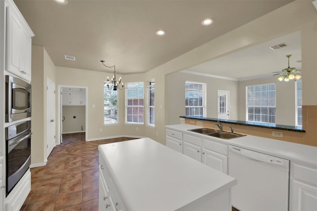 kitchen featuring stainless steel appliances, white cabinets, visible vents, and a sink