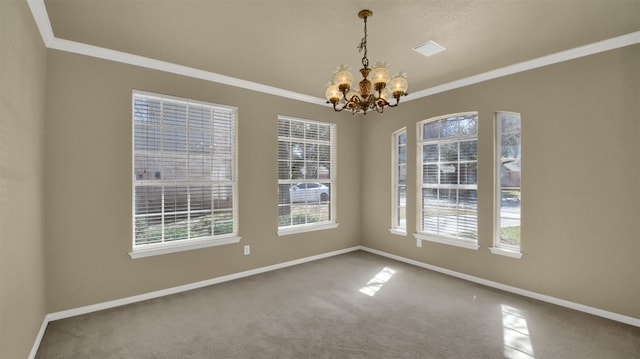 carpeted empty room featuring ornamental molding, a healthy amount of sunlight, a notable chandelier, and baseboards