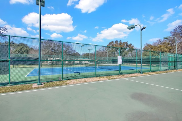 view of tennis court with fence