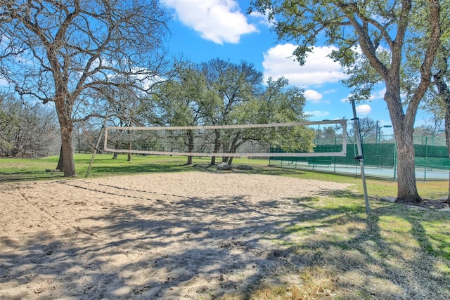 surrounding community with fence and volleyball court