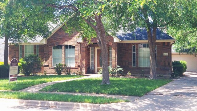 view of front of house with brick siding and a front yard