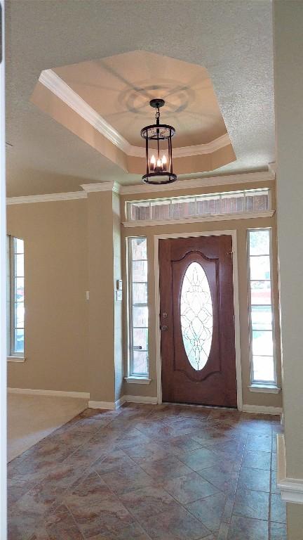 2002 Wood Glen Dr, Round Rock, TX 78681 - entryway with a tray ceiling, ornamental molding, baseboards, and a chandelier