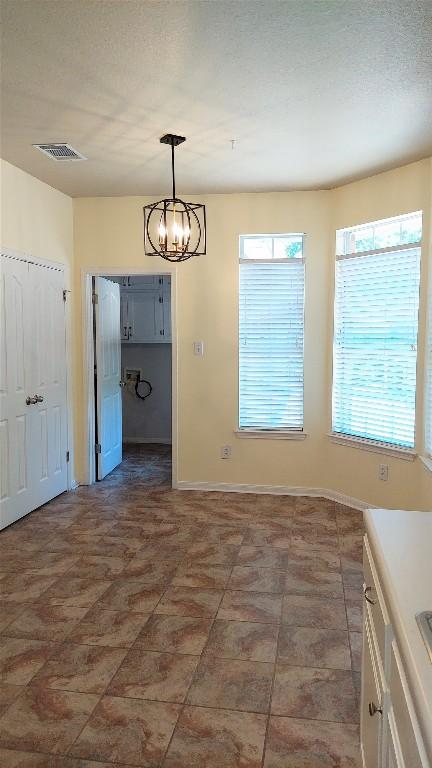 2002 Wood Glen Dr, Round Rock, TX 78681 - unfurnished dining area with a chandelier and baseboards