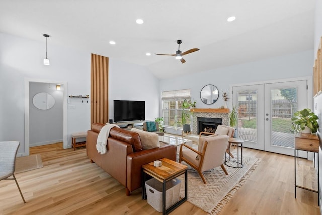 living area with vaulted ceiling, french doors, a wealth of natural light, and light wood-style floors