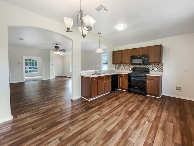 12804 Sago Palm Trl, Elgin, TX 78621 - kitchen with black appliances, dark wood-type flooring, light countertops, a ceiling fan, and hanging light fixtures