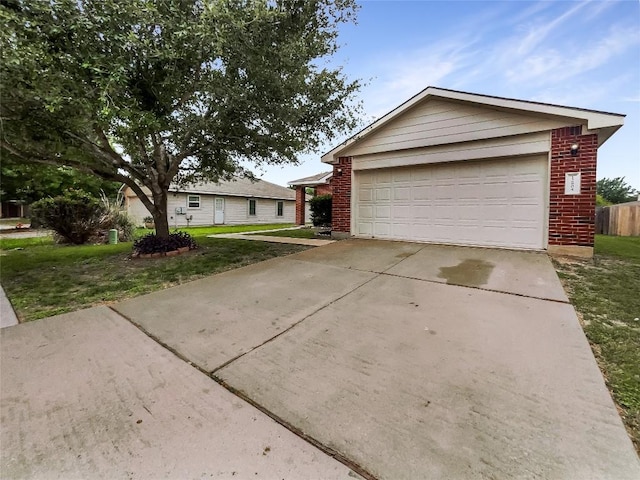 12804 Sago Palm Trl, Elgin, TX 78621 - view of front of house with brick siding, a garage, a front lawn, and concrete driveway