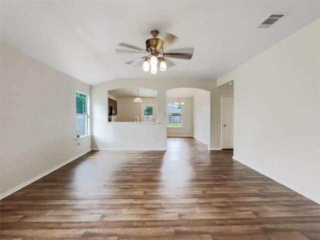 12804 Sago Palm Trl, Elgin, TX 78621 - unfurnished living room with arched walkways, wood finished floors, and a ceiling fan