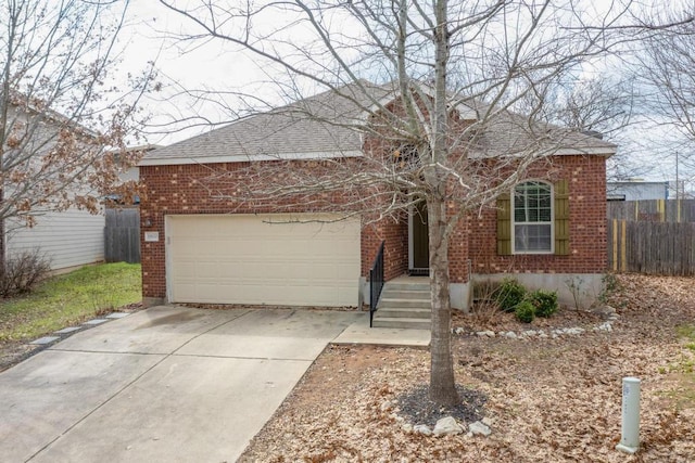 view of front of property featuring brick siding, an attached garage, driveway, and fence