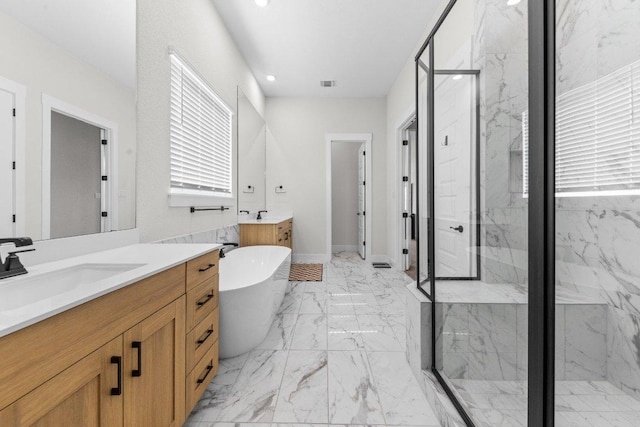 bathroom featuring a freestanding tub, a sink, visible vents, marble finish floor, and a marble finish shower