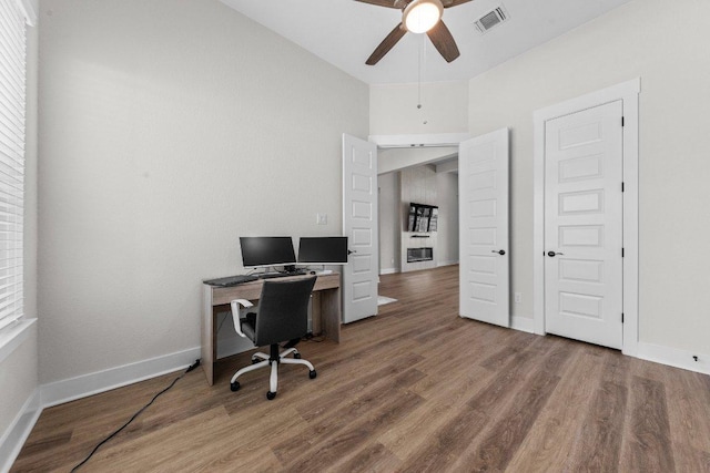 home office featuring visible vents, ceiling fan, baseboards, and wood finished floors