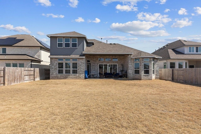 back of property featuring a fenced backyard and a lawn