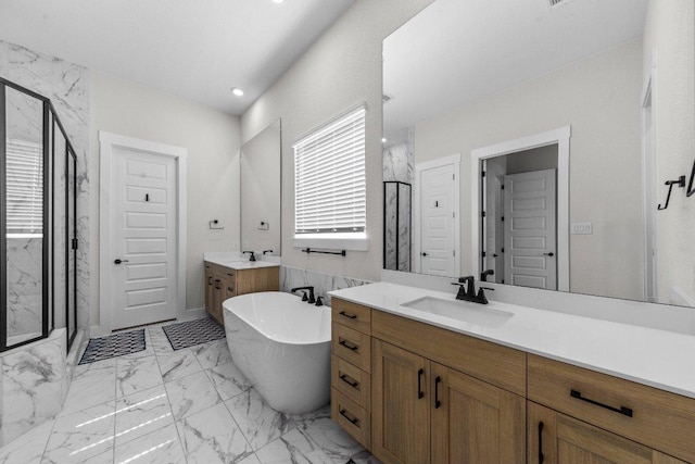 bathroom featuring marble finish floor, a sink, a freestanding bath, and a marble finish shower