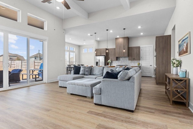 living area with recessed lighting, a ceiling fan, light wood-type flooring, beamed ceiling, and baseboards