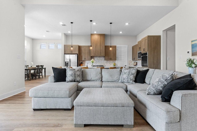 living room featuring light wood-type flooring, baseboards, visible vents, and recessed lighting