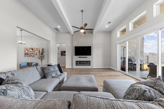 living area with light wood finished floors, baseboards, visible vents, beamed ceiling, and a fireplace