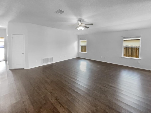 unfurnished room featuring visible vents, dark wood finished floors, and a textured ceiling