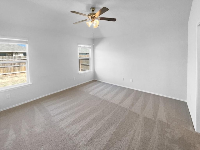 empty room featuring carpet, baseboards, and a ceiling fan