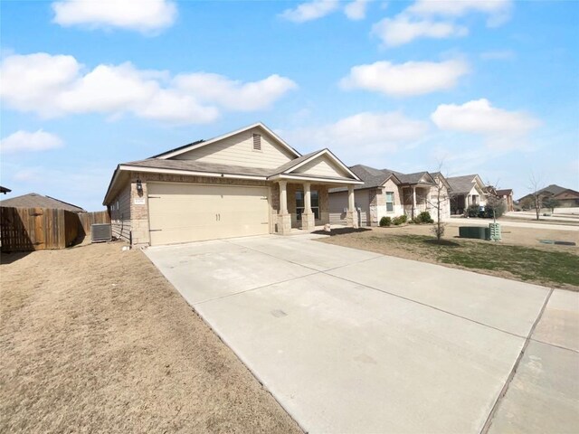 106 Lillian Dr, Taylor, TX 76574 - view of front of property with driveway, an attached garage, covered porch, brick siding, and stone siding