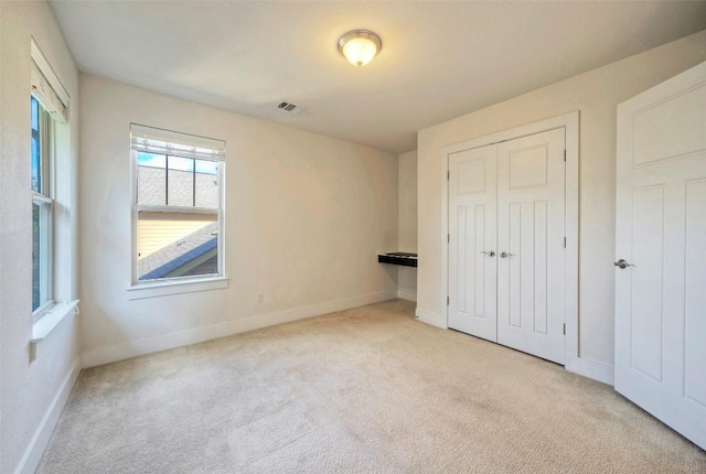 unfurnished bedroom featuring a closet, visible vents, baseboards, and carpet flooring