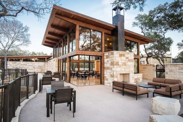 view of patio featuring an outdoor living space with a fireplace and fence