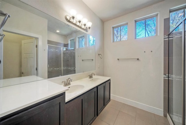 bathroom with a stall shower, tile patterned flooring, a sink, and baseboards