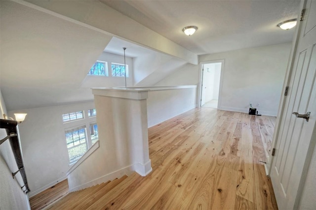 additional living space featuring baseboards and light wood finished floors