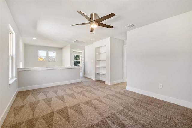 interior space with ceiling fan, built in features, visible vents, and baseboards