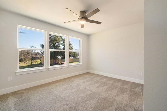 unfurnished room with ceiling fan, baseboards, and light colored carpet
