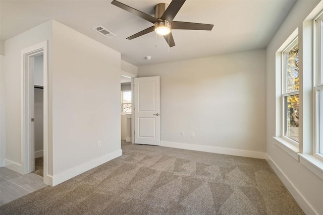 unfurnished bedroom featuring carpet floors, baseboards, visible vents, and a ceiling fan