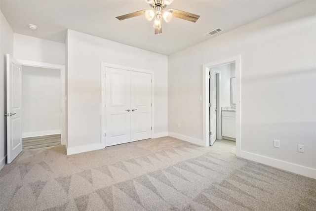 unfurnished bedroom with visible vents, light carpet, and baseboards