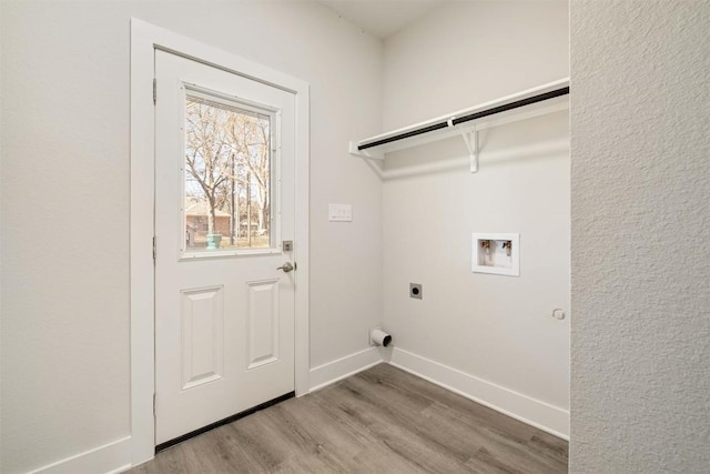washroom with hookup for a washing machine, hookup for an electric dryer, laundry area, wood finished floors, and baseboards