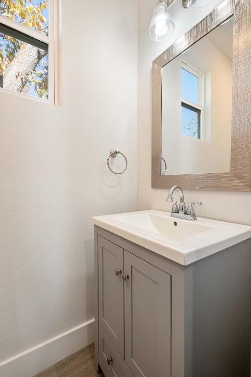 bathroom featuring wood finished floors, vanity, and baseboards