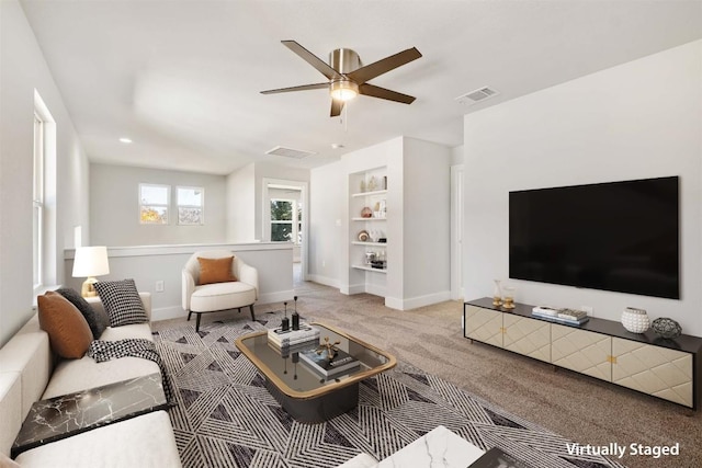 carpeted living room featuring built in features, visible vents, and baseboards