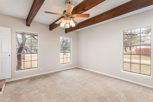 unfurnished room featuring a textured ceiling, beamed ceiling, carpet, and baseboards